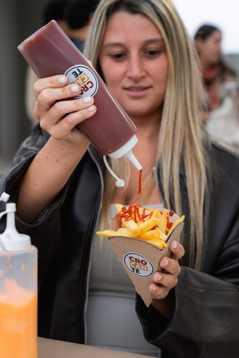 Cono de papas fritas con salsa cayendo encima